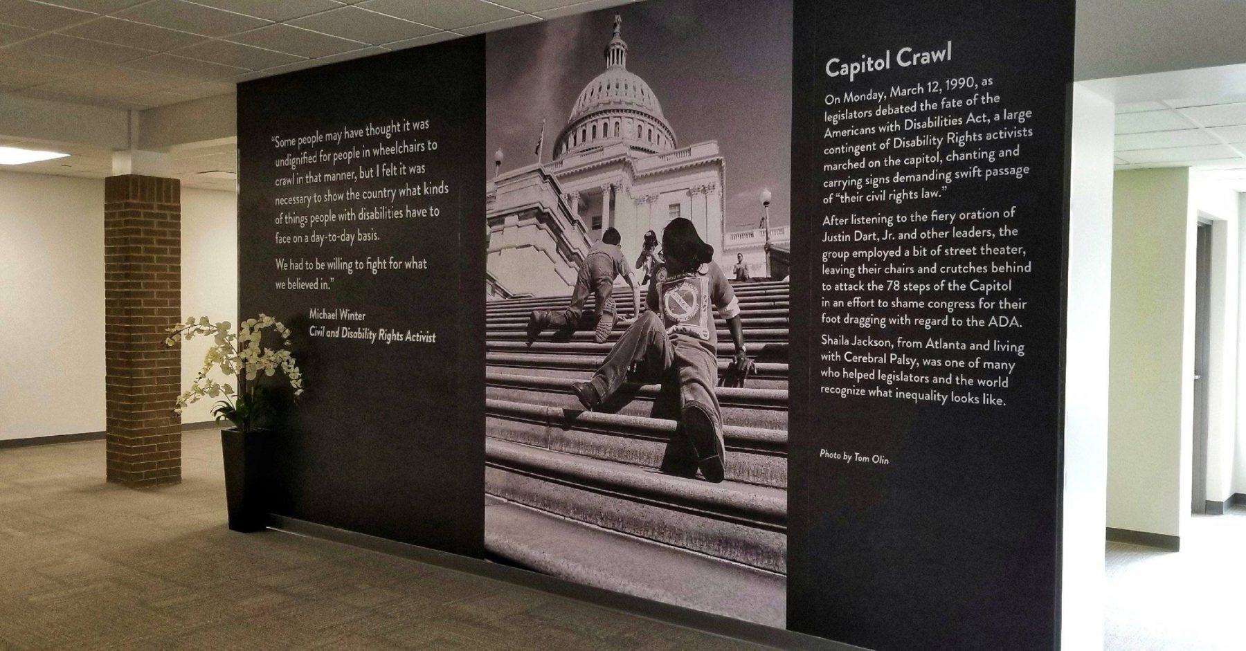 Interior hallway with Tom Olin's work - a large black and white photo of people crawling up the steps of the U.S. Capitol building in Washington, DC